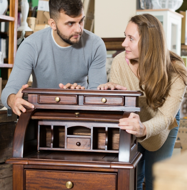 man and woman holding an antique wooden table