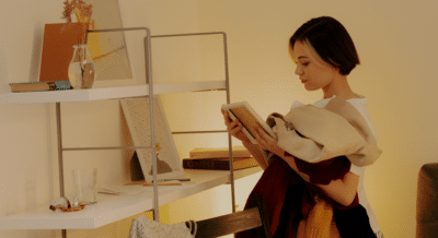 A woman looks longingly at a picture Fram in a room that's being packed up.