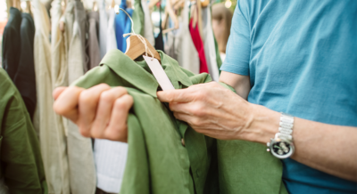 A man looks at the tag of a green shirt at an estate sale
