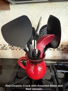 Red-Ceramic-Crock-with-Assorted-Black-and-Red-Utensils