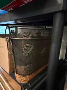 Decorative-Metal-Wastebasket-with-Tropical-Leaf-Motifs-and-Woven-Base