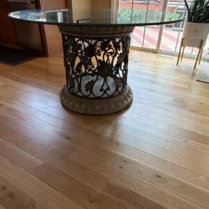 Round-Glass-Top-Dining-Table-with-Ornate-Forged-Iron-Base