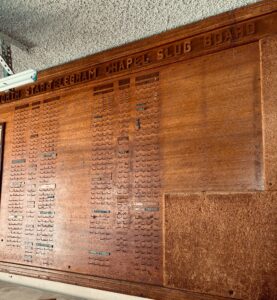 Museum-Quality Fort Worth Star-Telegram Chapel Slug Board An extraordinary original Fort Worth Star-Telegram Chapel Slug Board, measuring an impressive 4' x 8', used in the newspaper's composing room to organize printers, operators, machinists, proof room staff, and other production departments. This handcrafted hardwood board features carved lettering, original department nameplates, hundreds of brass hooks, and the original framed "Rules & Regulations – Star-Telegram Chapel Mutual Aid Society." A rare surviving piece of Fort Worth and newspaper history, this would make an incredible focal point in a home, restaurant, brewery, office, library, museum, or commercial space.