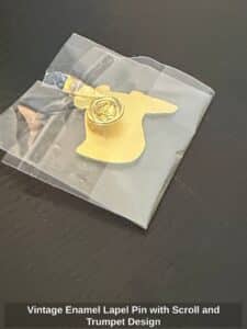 Vintage-Enamel-Lapel-Pin-with-Scroll-and-Trumpet-Design-second-image