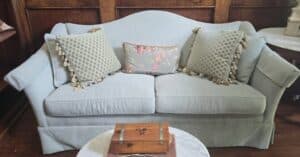 Light-Blue-Upholstered-Camelback-Sofa-with-Decorative-Pillows