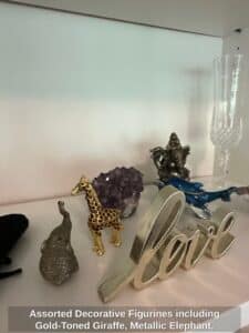 Assorted-Decorative-Figurines-including-Gold-Toned-Giraffe-Metallic-Elephant-Blue-Whale-Silver-Love-Sculpture-Ganesha-Statue-and-Crystal-Champagne-Flute
