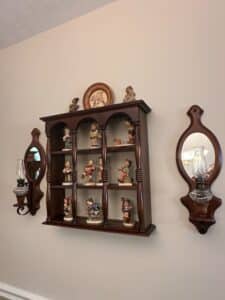 Hummel-Figurine-Collection-with-Wooden-Display-Shelf-and-Wall-Sconces