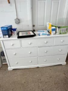 White-Drawer-Dresser-with-Framed-Art-and-Assorted-Boxes
