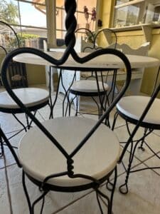 Wrought-Iron-Bistro-Set-with-Heart-Back-Chairs-and-Amber-Glass-Oil-Lamp-third-image