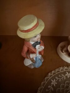 Porcelain-Figurine-of-a-Boy-with-a-Camera-and-Blue-Bundle