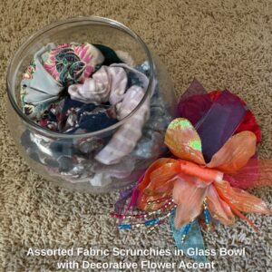 Assorted-Fabric-Scrunchies-in-Glass-Bowl-with-Decorative-Flower-Accent