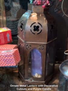 Ornate-Metal-Lantern-with-Decorative-Cutouts-and-Purple-Candle