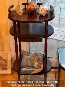 Vintage-Three-Tiered-Pedestal-Table-with-Pig-Figurines-and-Leopard-Tapestry