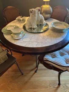 Round-Marble-Top-Dining-Table-with-Wrought-Iron-Base-and-Cane-Back-Chairs
