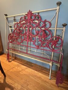 Victorian-Cast-Iron-Bed-Frame-with-Red-Decorative-Panel-and-Ornate-Scrollwork