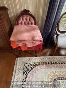 Victorian-Tufted-Accent-Chair-with-Stacked-Blankets