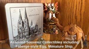 Assorted-Souvenir-Collectibles-including-Faberge-style-Egg-Miniature-Ship-Egyptian-Mug-Matryoshka-Doll-Cologne-Cathedral-Tin-and-Camel-Figurine-second-image