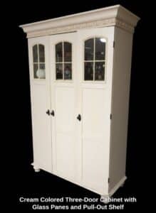Cream-Colored-Three-Door-Cabinet-with-Glass-Panes-and-Pull-Out-Shelf
