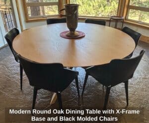 Modern-Round-Oak-Dining-Table-with-X-Frame-Base-and-Black-Molded-Chairs