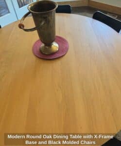 Modern-Round-Oak-Dining-Table-with-X-Frame-Base-and-Black-Molded-Chairs-fourth-image