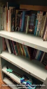 Painted-Wooden-Bookcase-with-Childrens-Books-and-Ukulele