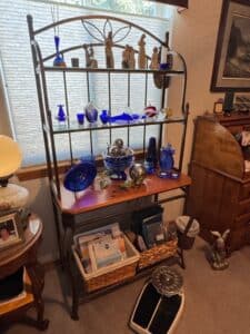 Wrought-Iron-Bakers-Rack-with-Assorted-Decorative-Glassware-and-Figurines
