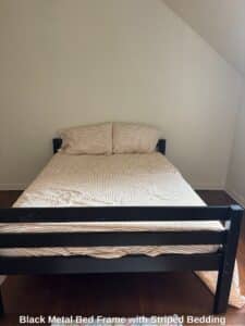 Black-Metal-Bed-Frame-with-Striped-Bedding