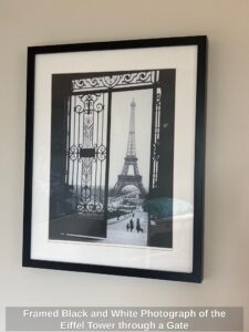Framed-Black-and-White-Photograph-of-the-Eiffel-Tower-through-a-Gate