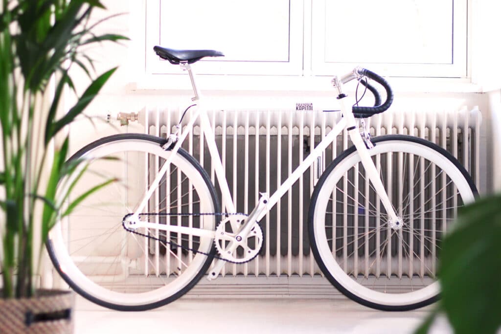 A white bike in front of a white radiator