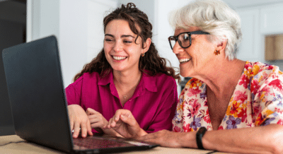 Senior woman and adult daughter researching downsizing options online