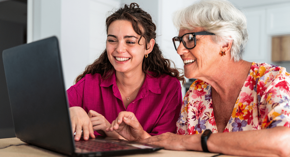 Senior woman and adult daughter researching downsizing options online